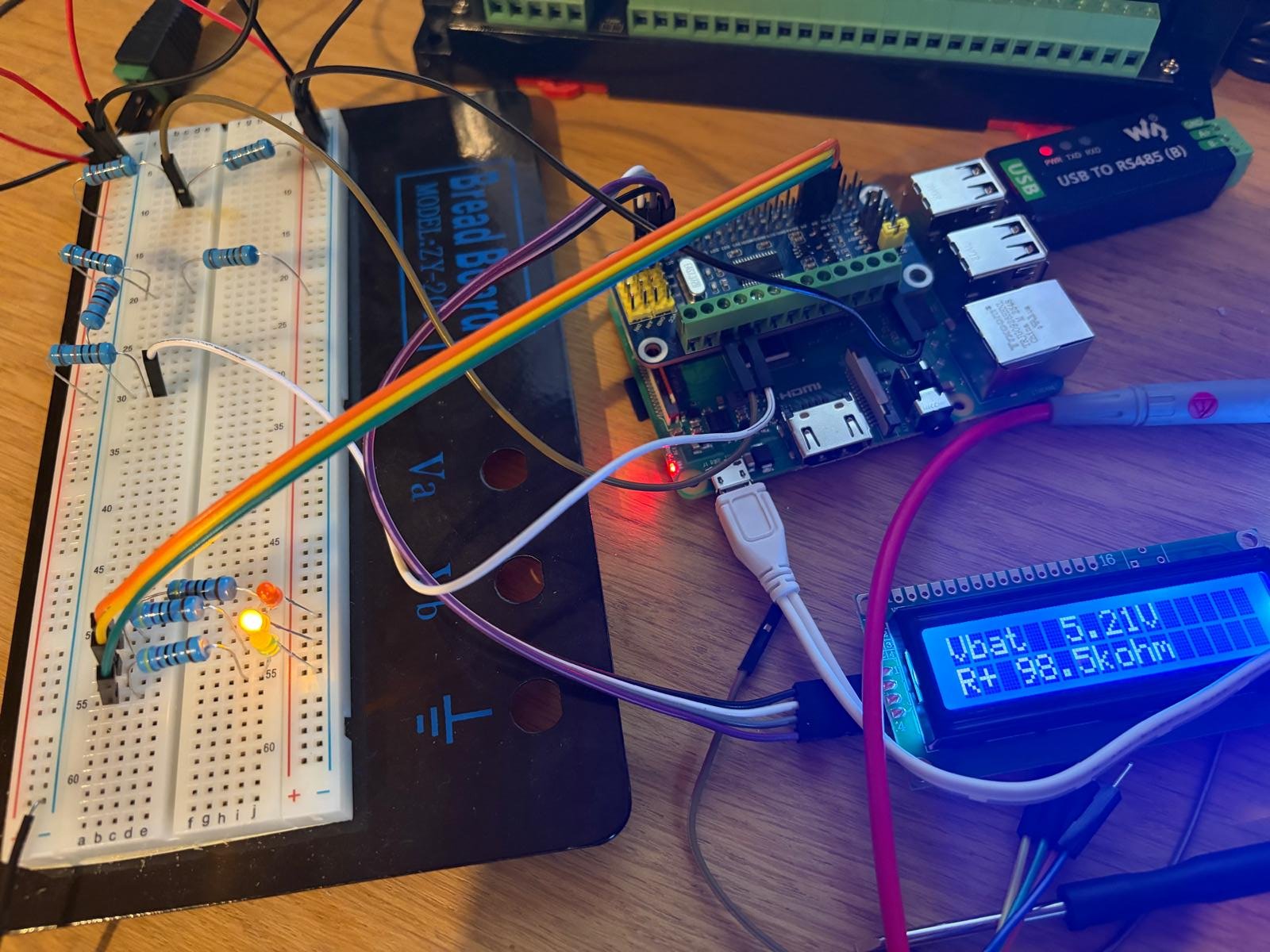 The HullSentry proof of concept on a breadboard: Raspberry Pi, test resistors and an LCD showing Vbat 5.21 V and an R+ reading of 98.5 kΩ
