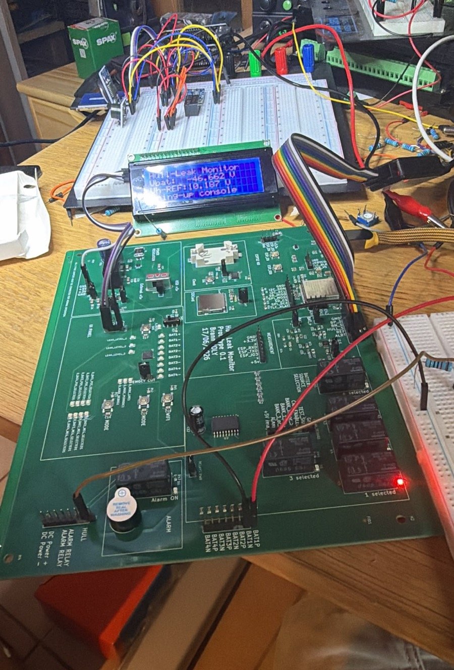 First HullSentry working prototype: green PCB with relays, buzzer and an LCD, during bring-up on the workbench